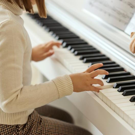 Mädchen spielt auf einem Klavier